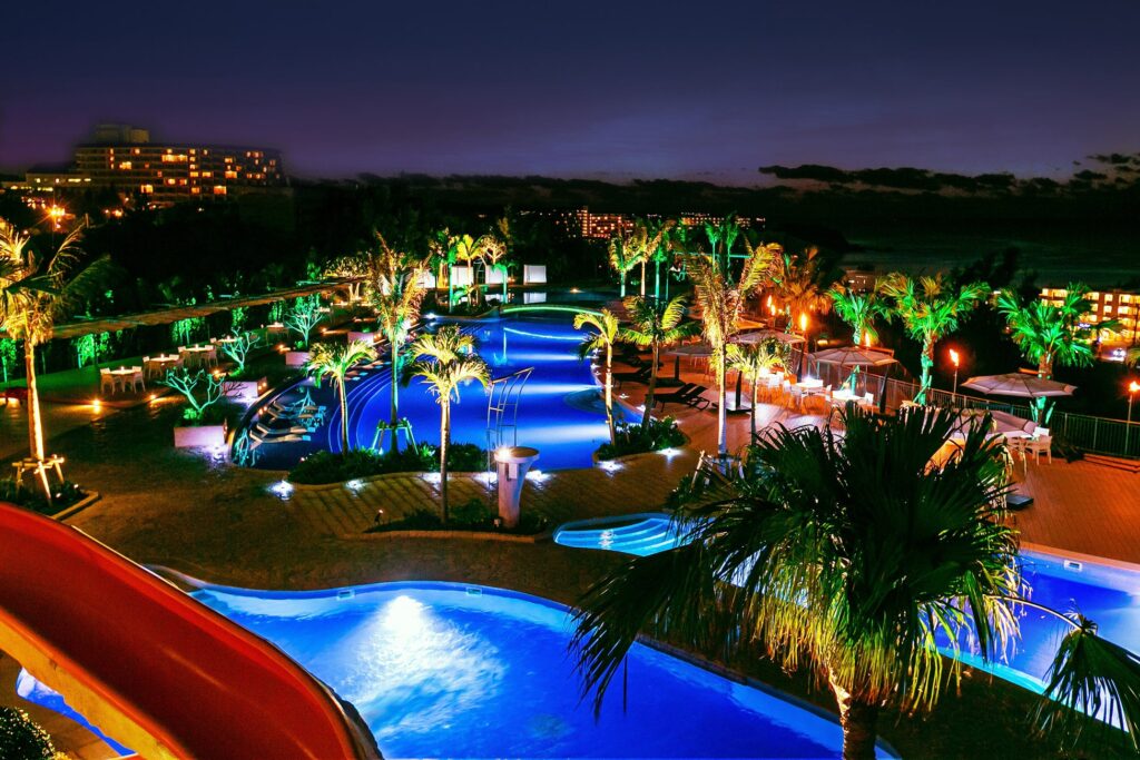 沖縄リゾートホテルのライトアップされた夜のプール全景