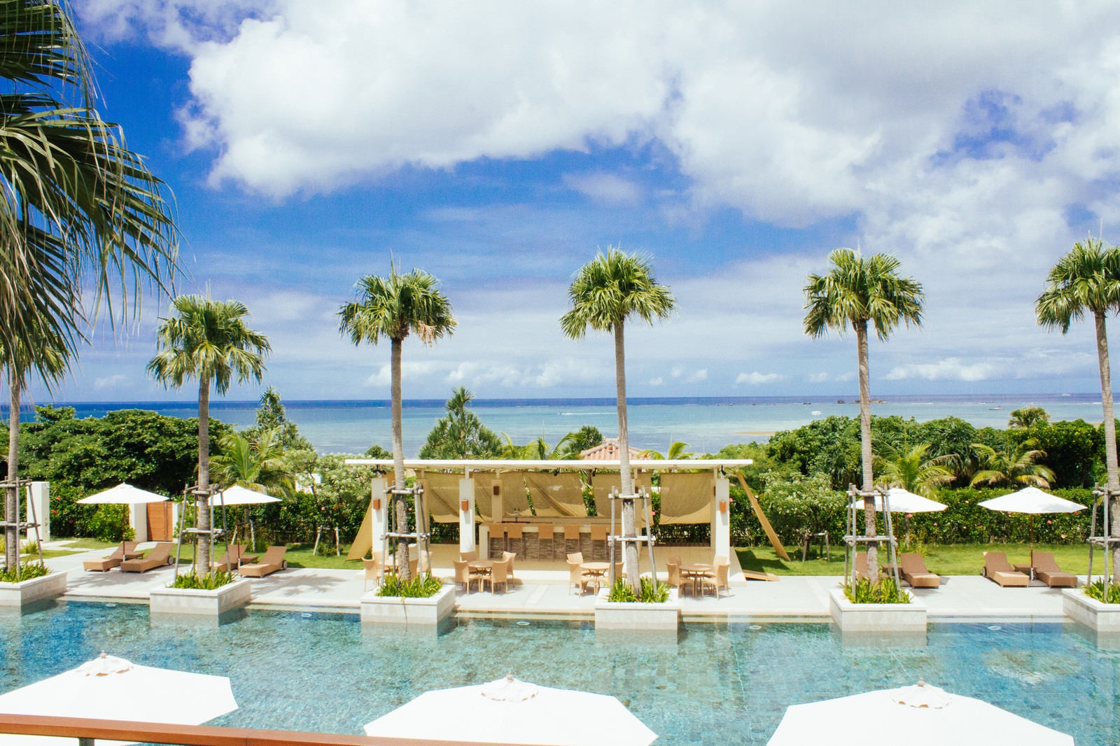 沖縄のリゾートホテルのプールとヤシの木の風景