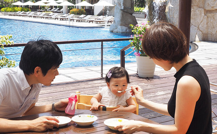沖縄のリゾートホテルのプールで楽しむ子連れファミリー
